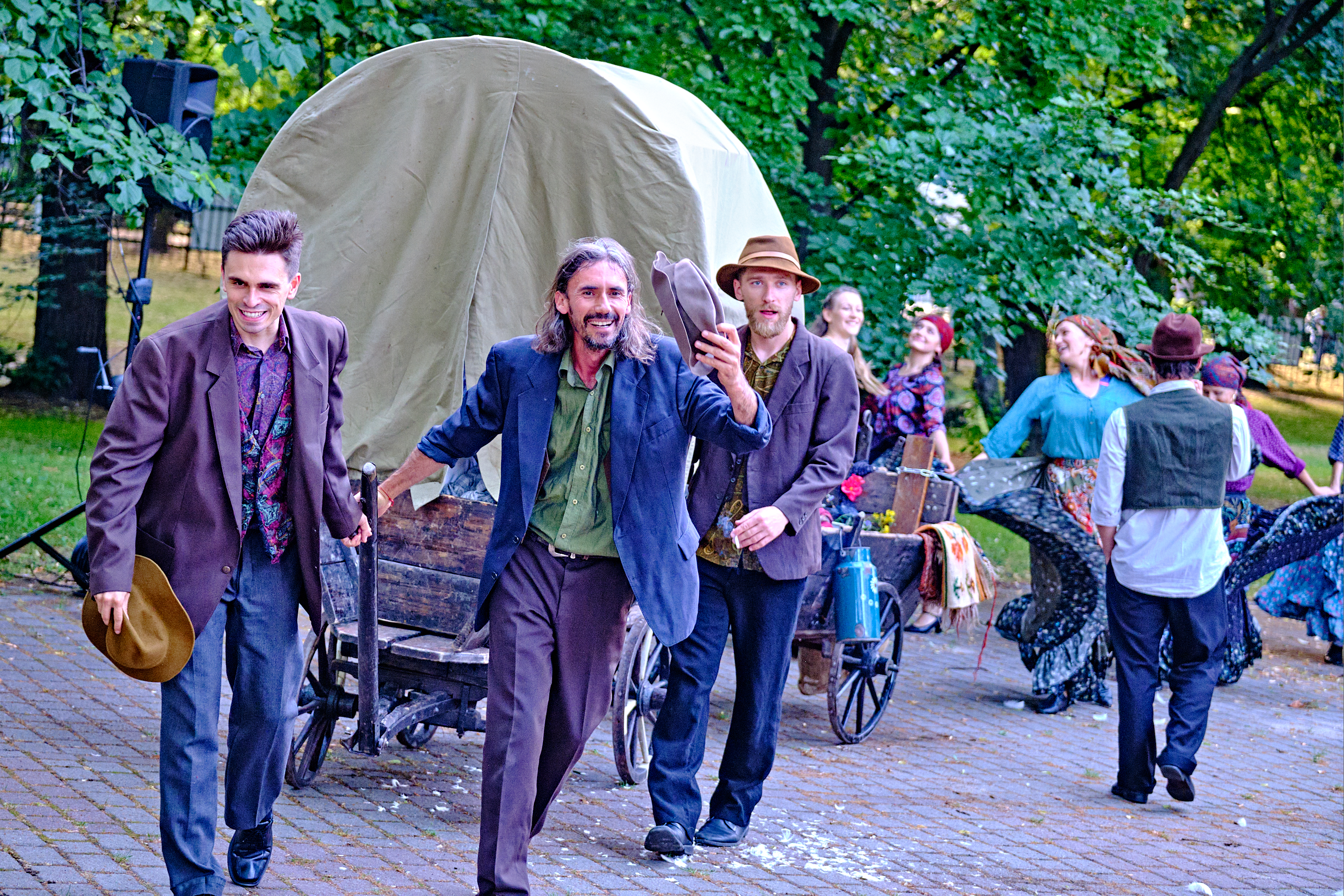 Teatr Migro – „DROM – ścieżkami Romów” grupa aktorów, w tle cygański wóz