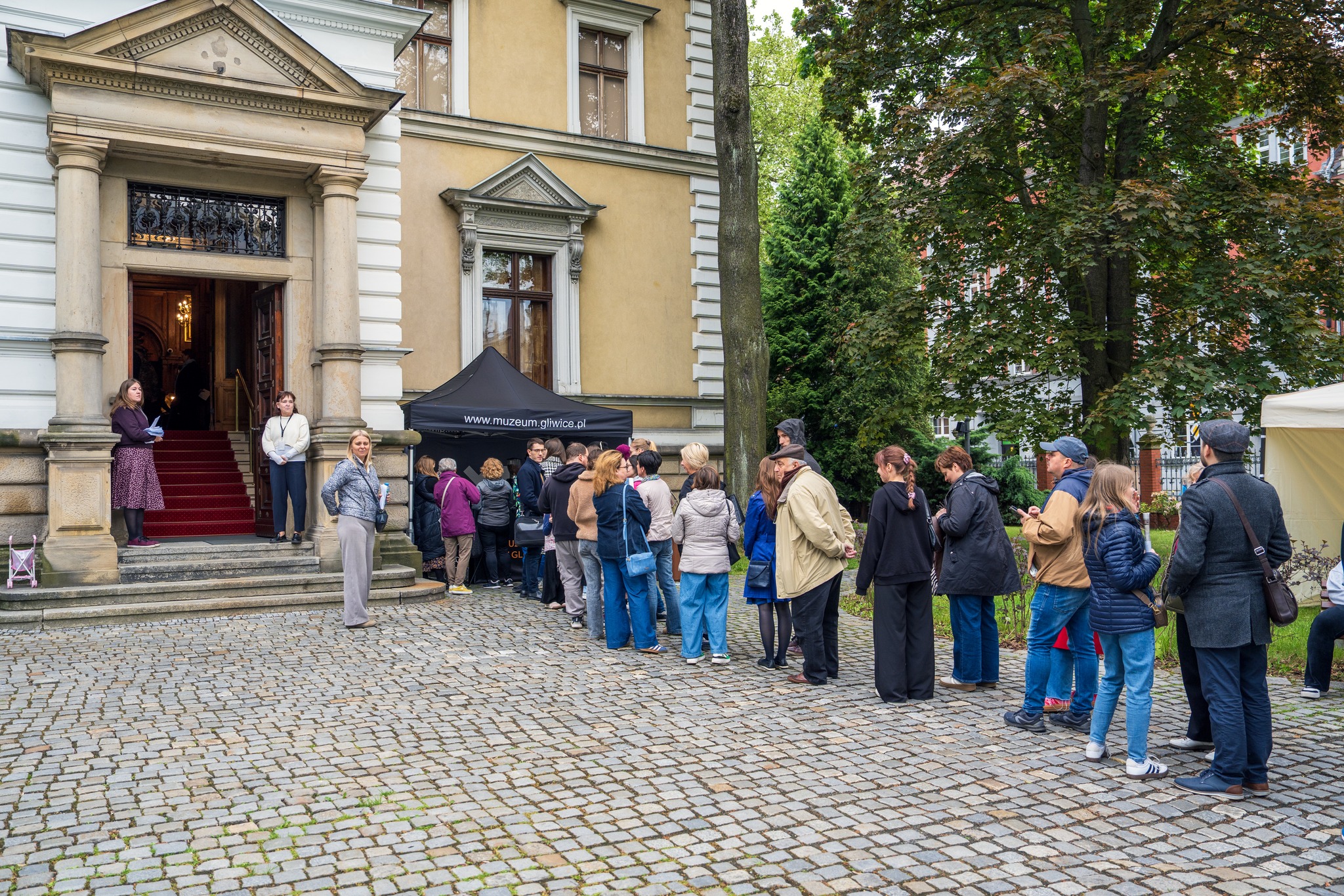 ludzie w kolejnce przed muzeum