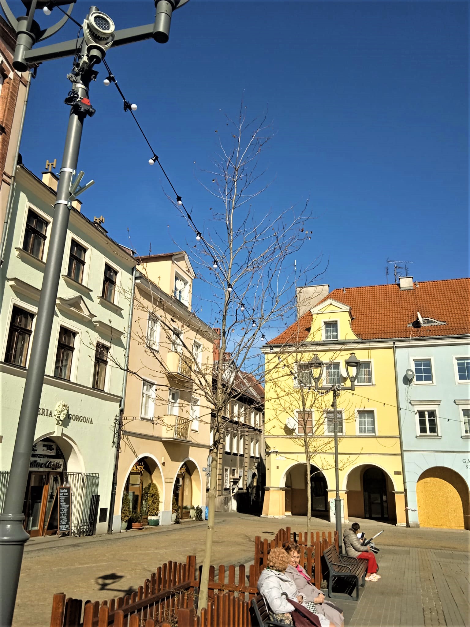 lampki na latarniach, ludzie na ławkach na Rynku