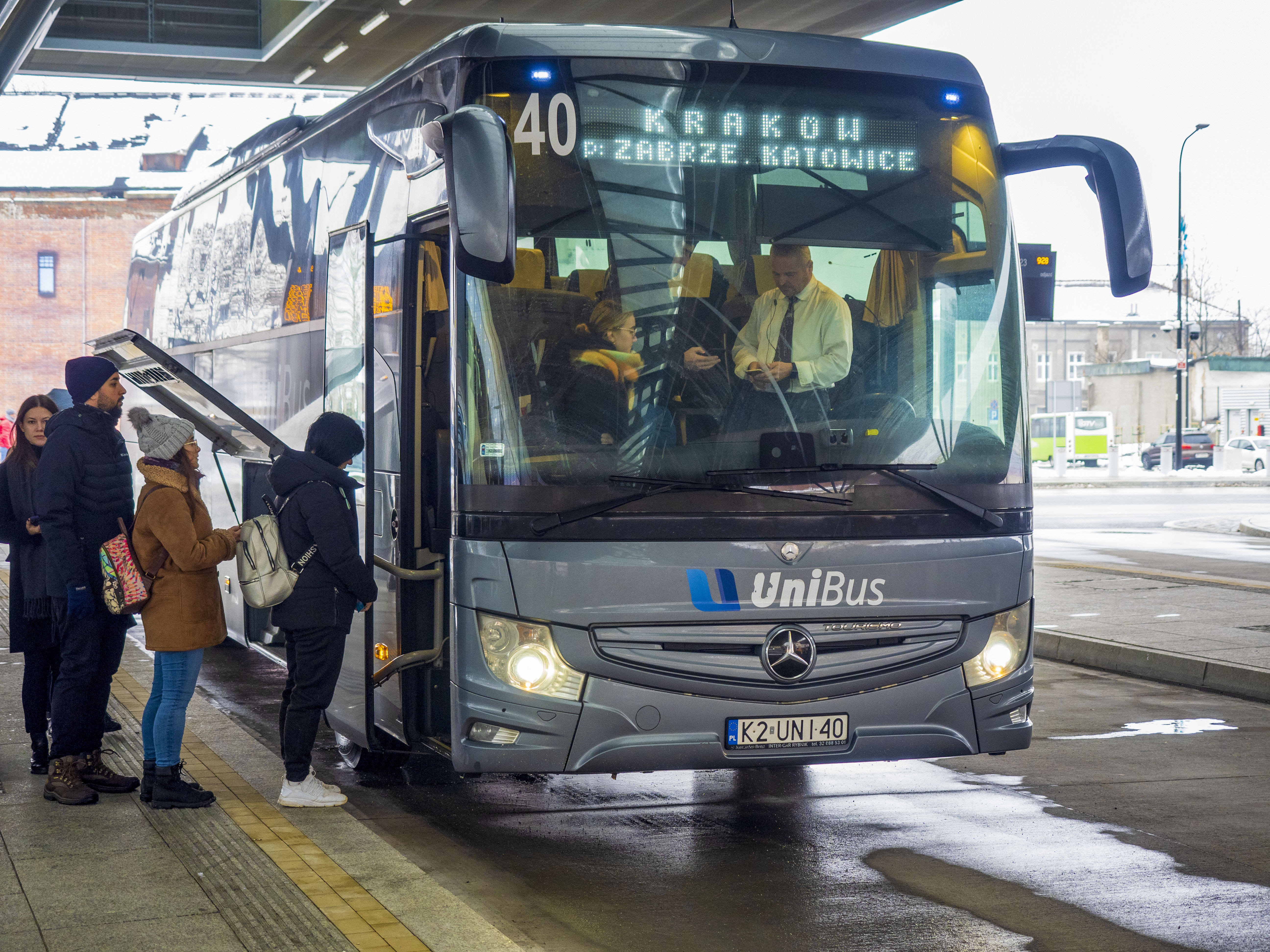 pasażerowie wsiadający do autobusu