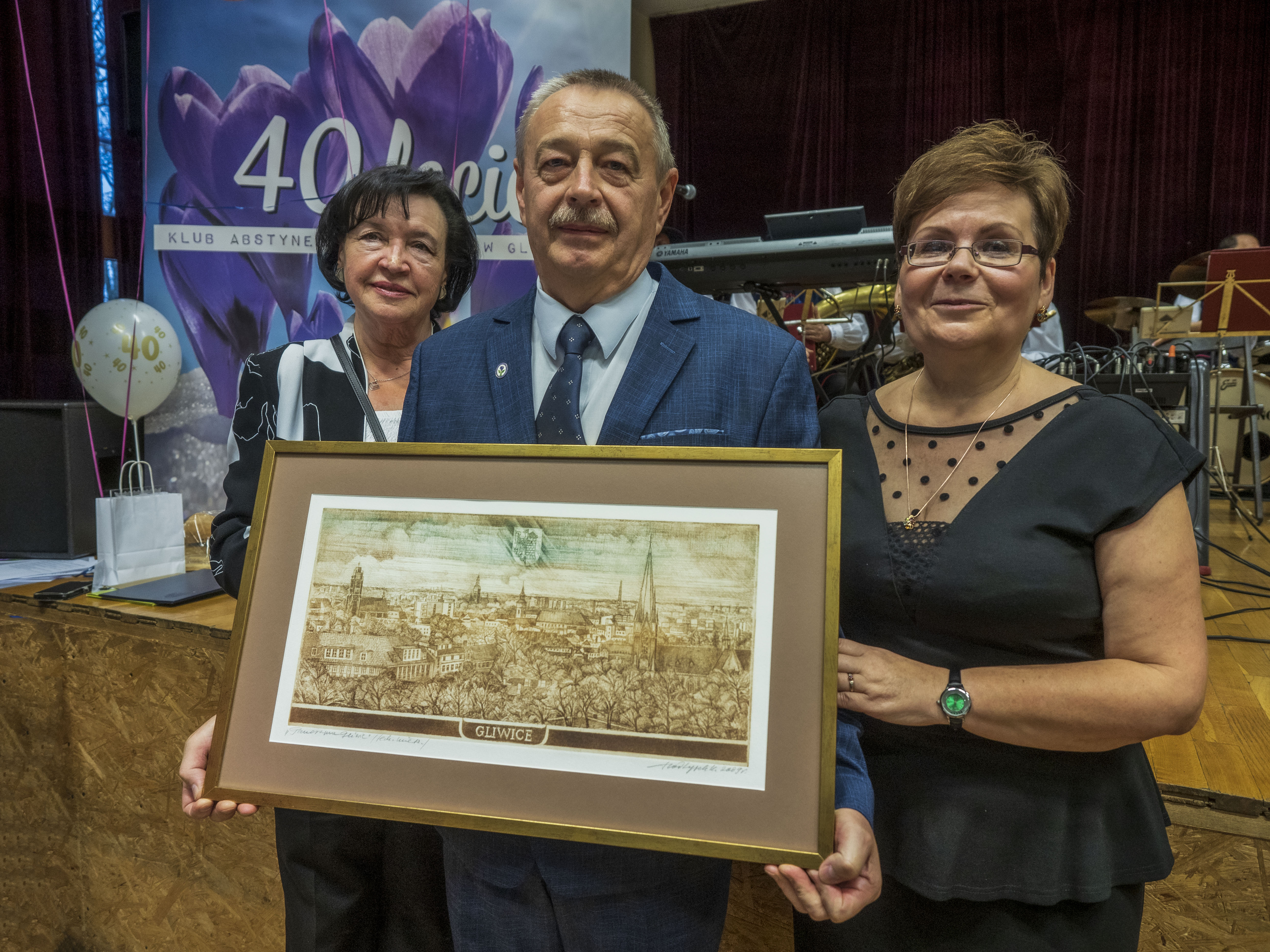 Wiceprzewodnicząca Rady Miasta Gliwice Krystyna Sowa, prezes Stowarzyszenia Krokus i Maria Stefanik, skarbnik klubu rycinę z panoramą Gliwic. W jubileuszu 40-lecia działalności Klubu Abstynenta kusem" 