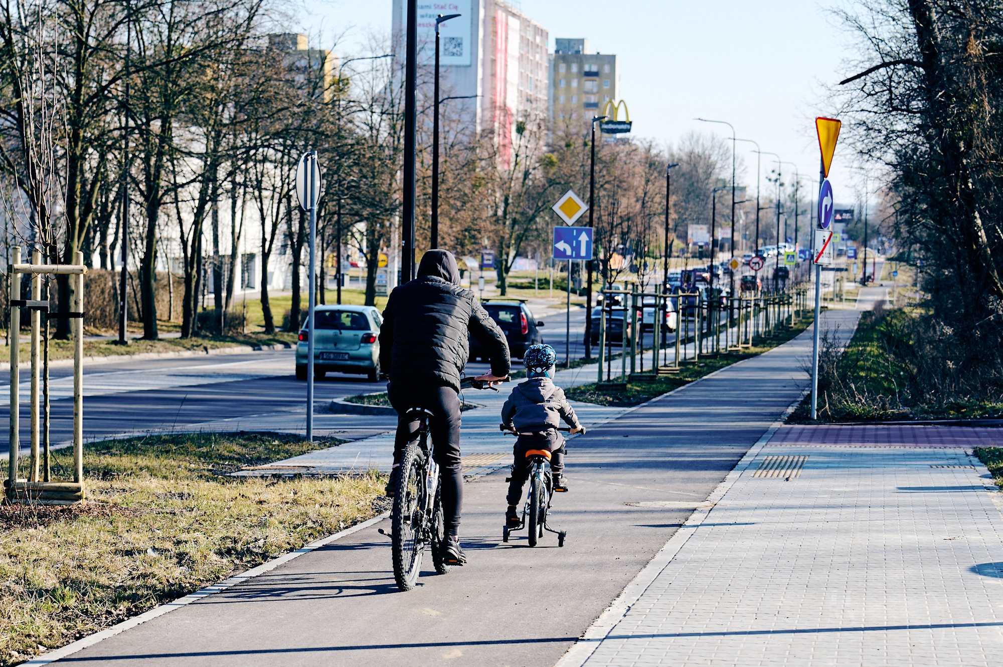 Ojciec z synem jadący na rowerach ścieżką wzdłuż ul. Toszeckiej