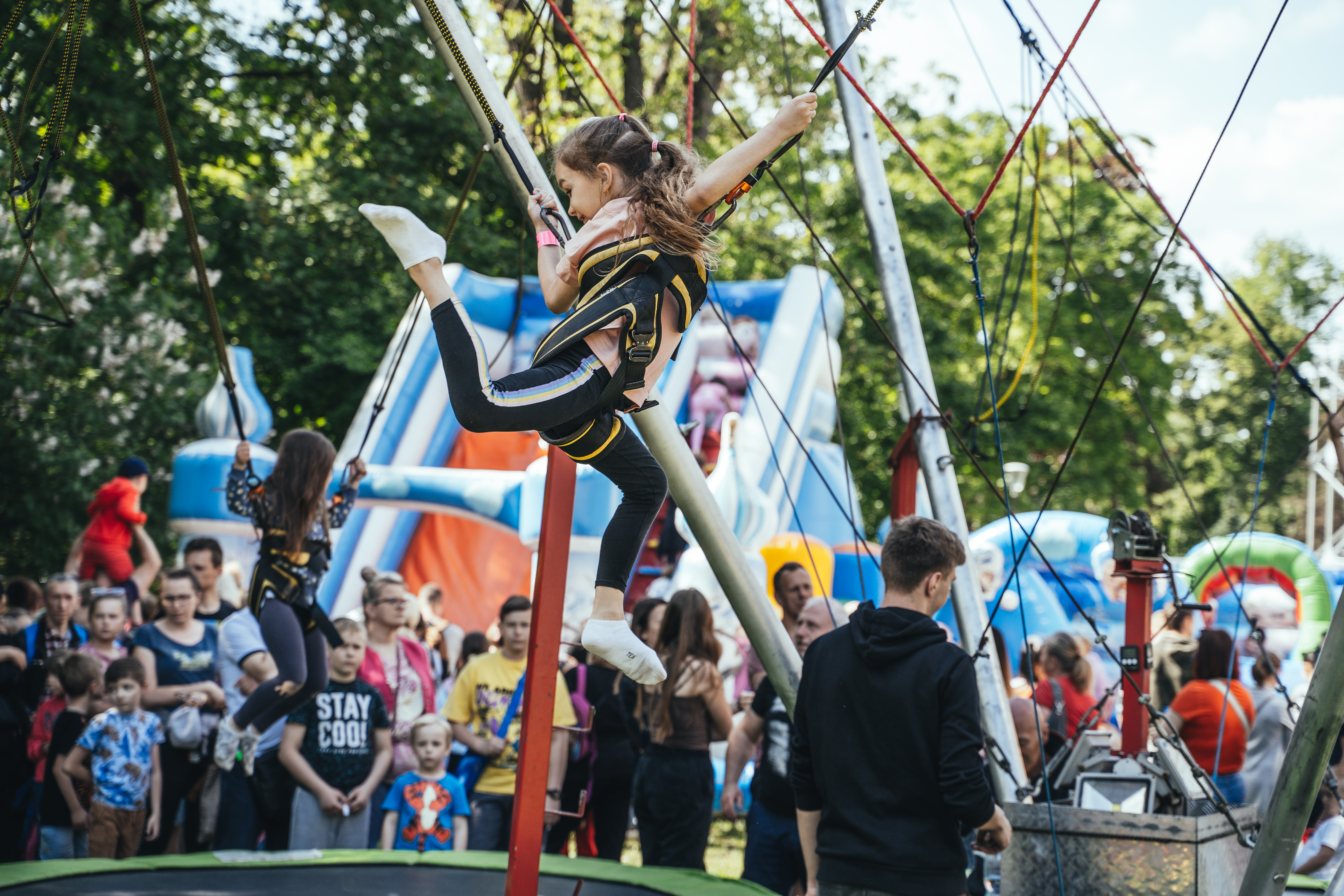 dziecko na taśmach skacze na trampolinie