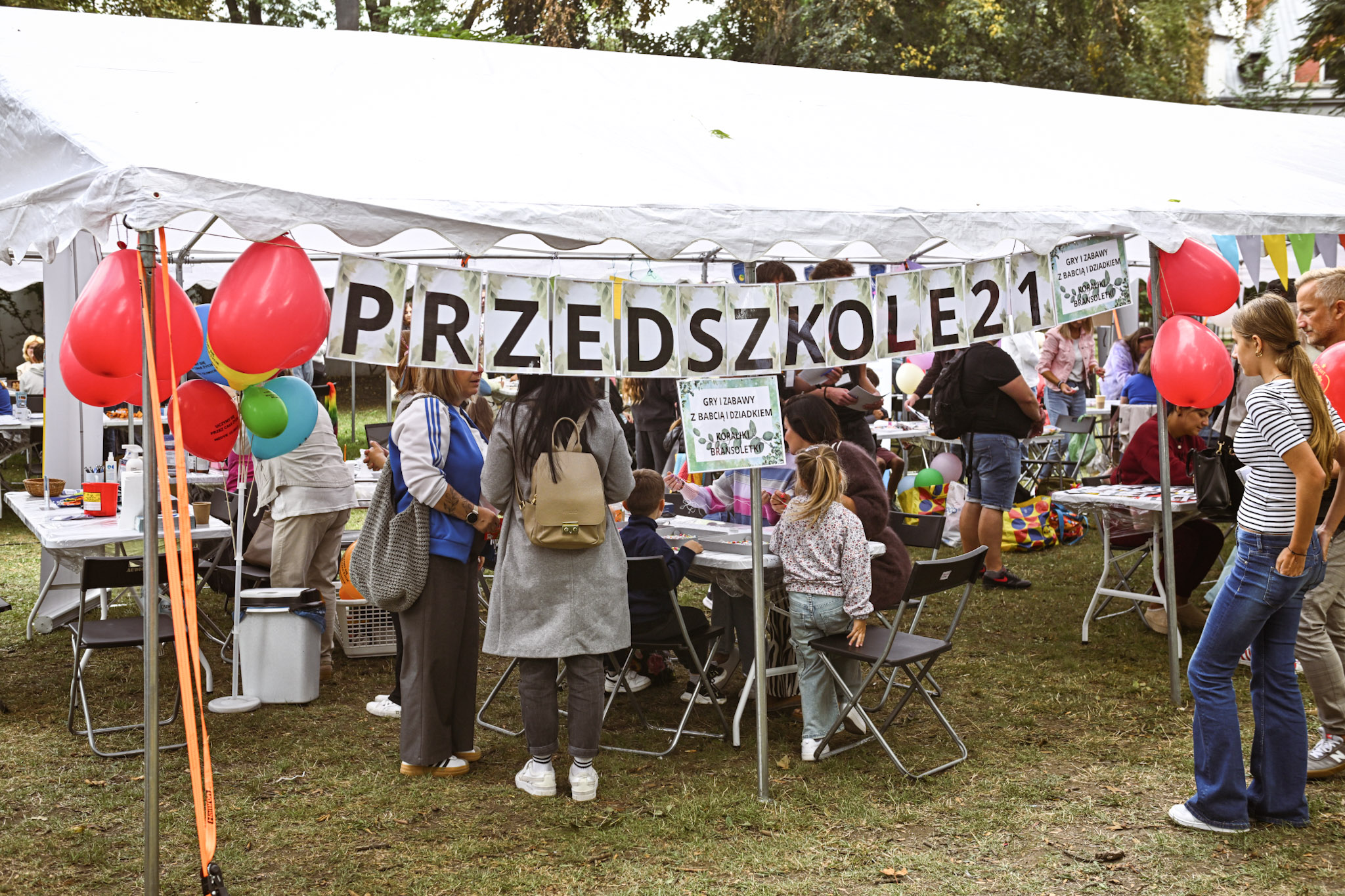 ludzie pod namiotami z atrakcjami