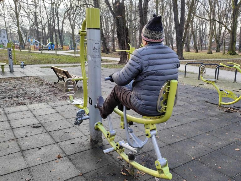 człowiek ćwiczy na siłowni plenerowej