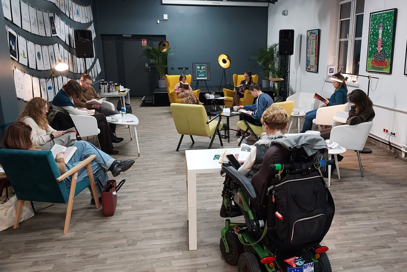 ludzie z książkami, w fotelach, czytają w bibliotece