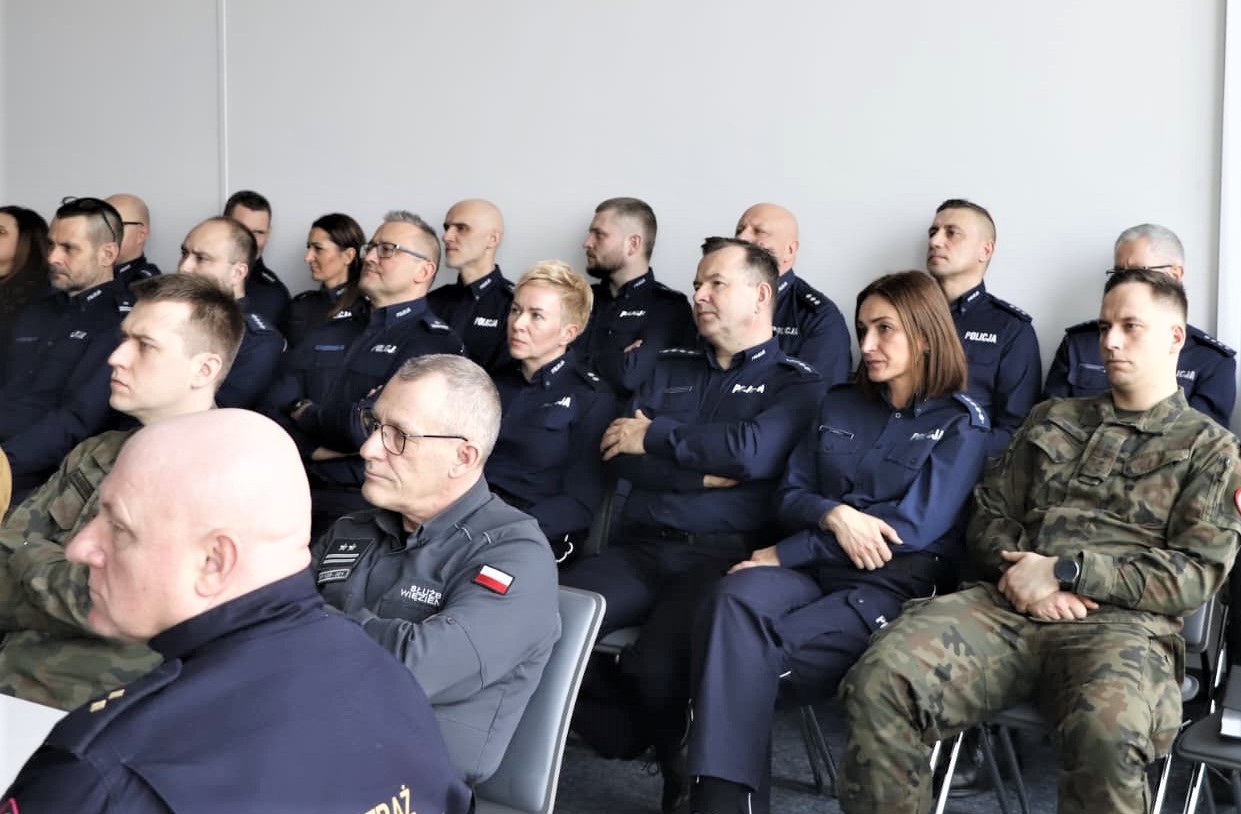 ludzie siedzący na krzesłach podczas odprawy