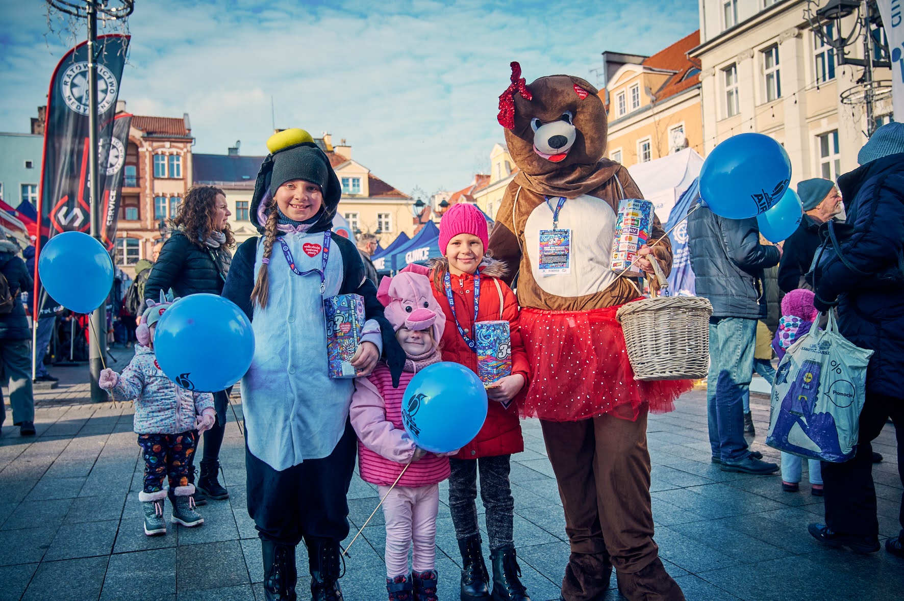 ludzie na |Rynku, jedna osoba przebrana za misia