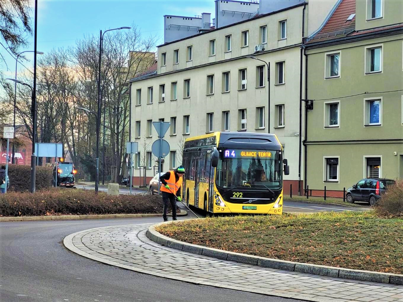 robotnik zamiata drogę, na rondo wjeżdża autobus